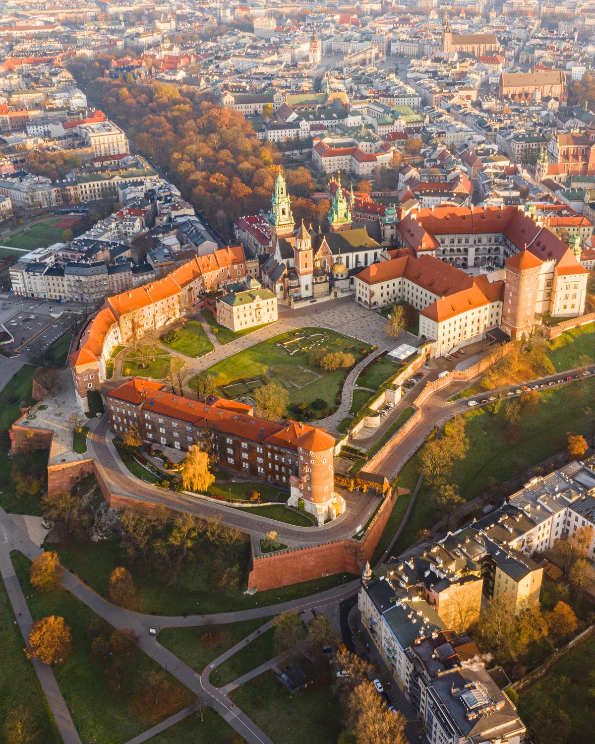 Aerial view of Wawel Castle at golden hour with Krakow's Old Town stretching behind it