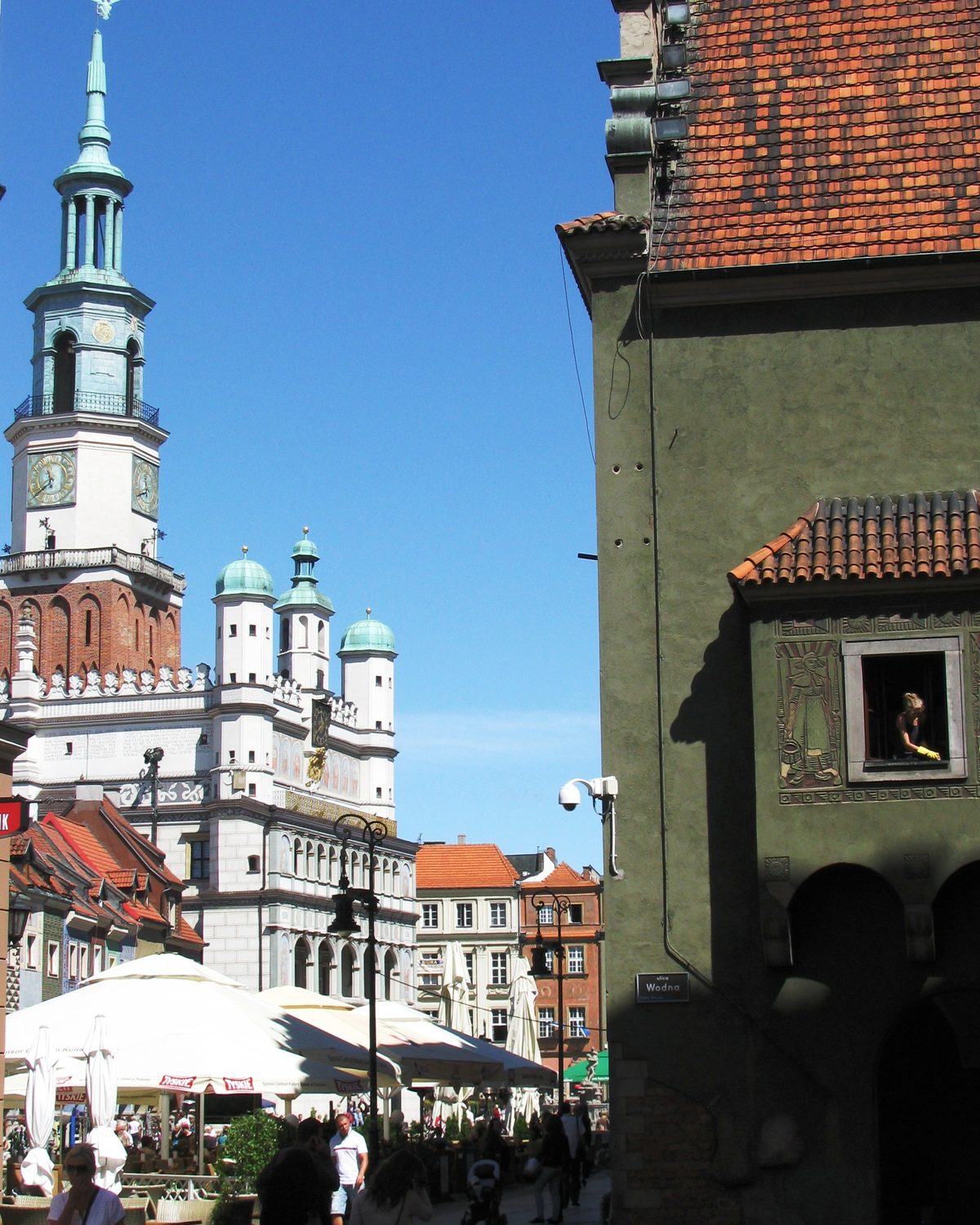 Poznań's Old Market Square with the Renaissance town hall tower rising above the café umbrellas