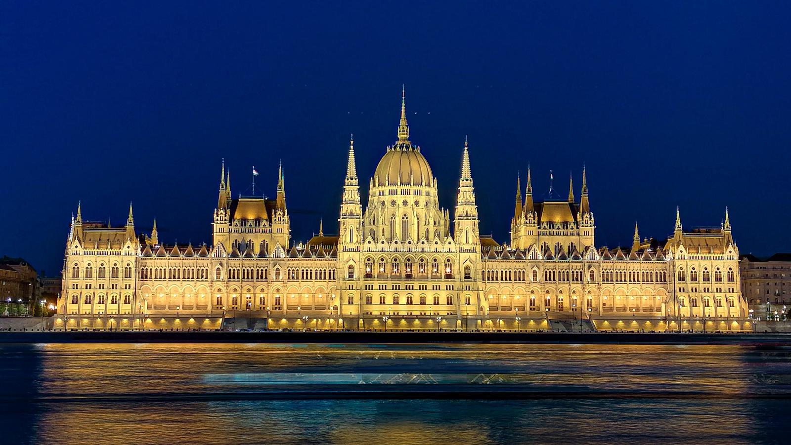 Hungarian Parliament Building illuminated at night reflected in the Danube River in Budapest