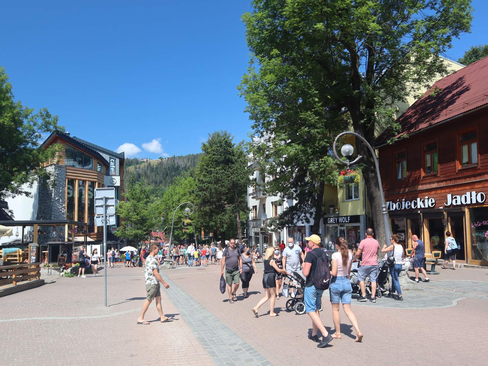 Krupówki promenade in Zakopane on a sunny summer day with the Tatra foothills in the background